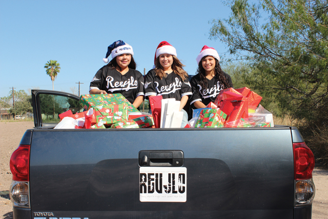 Members of REVJLO, a local non-profit organization, helped distribute toys to children at the Bent Tree subdivision on Christmas Day. REVJLO was founded by Juan Longoria, a San Benito High School graduate. (Courtesy photos)