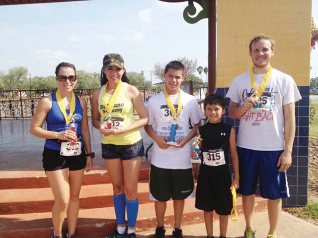Christina Araguz, Angelica Robles, Isaiah Treviño, Johnathan Ayala and Paul Cordes are shown at the Heavin Memorial Park amphitheater on Saturday after participating in the First Annual Child Abuse Prevention 5K Run/Walk in San Benito. (Photo by Christina R. Garza)