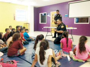 San Benito News photo by Francisco E. Jimenez Detective Rogelio Banda Jr. (kneeling) of the San Benito Police Department was joined Wednesday by fellow officer Carlos Romero in teaching kids at the Boys and Girls Club of San Benito about stranger danger.
