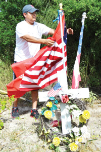 San Benito News photo by Francisco E. Jimenez Retired Army Staff Sergeant David Vasquez of Harlingen is seen maintaining a makeshift memorial off State Highway 100 near Los Fresnos, where Edoardo Polanco (inset), a Marine Corps veteran, was killed on March 18, 2012.