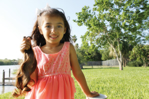 (Photo by Cecilia Gonzales) Five-year-old Angelin Garza of San Benito is seen with a handful of hair she had cut to donate to cancer patients experiencing hairloss as a result of chemotherapy treatment.