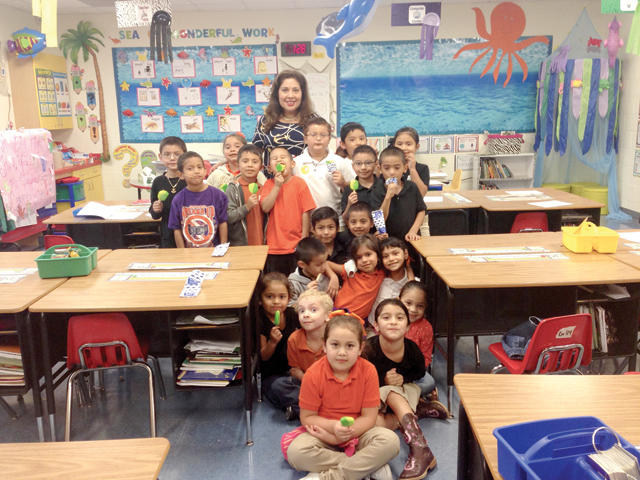 (Staff photo by Jacob Lopez) Laura Taylor, 2015 Regional Elementary Teacher of the Year, is seen with her first grade class at Angela G. Leal Elementary School in San Benito on Thursday, when Blue Bell Creameries provided ice pops for the 500-plus students and staff at the campus.